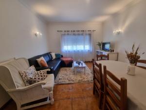 un soggiorno con un divano e un tavolo di Zinha's Guest House a Moledo