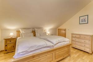 une chambre avec un grand lit avec des draps et des oreillers blancs dans l'établissement Wohnung Rachel, à Spiegelau