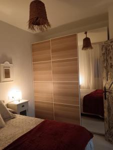 a bedroom with a large closet with a bed at Casas Rural Entre costuras in Setenil +8 photos