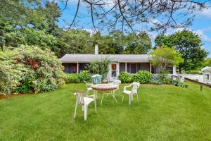 a table and chairs in the yard of a house at The Beach Bunny Cottage in Plymouth