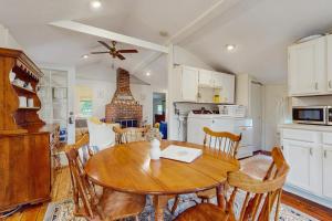 a kitchen and dining room with a wooden table and chairs at The Beach Bunny Cottage in Plymouth +15 photos
