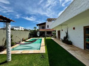 a house with a hammock in the yard at Casa Kuara in Trairi