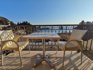 een tafel en twee stoelen op een balkon bij Avlonitis Rooms in Parga