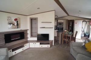 ein Wohnzimmer mit Flachbildfernseher und Couch in der Unterkunft Tranquil 3Bedroom Caravan Pets stay Free in Hunstanton