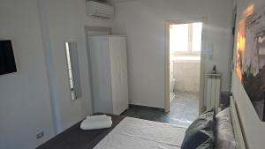 a white room with a bed and a mirror at Nina Camera in Sirolo