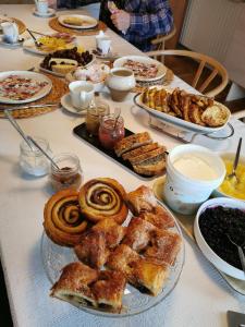 a table topped with plates of pastries and pies at TheGilgahouse gardenroom in Nakskov +2 photos