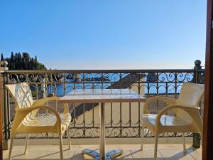 een tafel en twee stoelen op een balkon bij Avlonitis Rooms in Parga