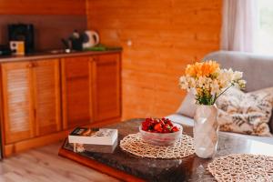 a table with a vase of flowers and a bowl of fruit at Polna Przystań 694-272-463 in Uherce Mineralne (7)