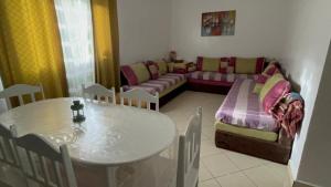 a living room with a table and a couch at Beau appartement à saidia in Saïdia