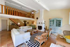 a living room with white furniture and a staircase at Villa with 5 Bedrooms and Private Pool in Grimaud