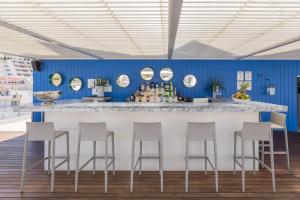 a bar with four stools in a room with blue walls at Hotel Baltum in Albufeira