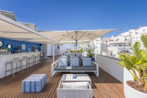 a rooftop patio with chairs and an umbrella at Hotel Baltum in Albufeira