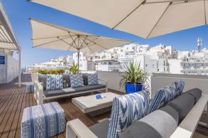 a balcony with chairs and a table and an umbrella at Hotel Baltum in Albufeira