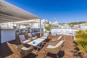 a patio with chairs and tables on a deck at Hotel Baltum in Albufeira