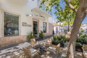 a patio with chairs and a table in front of a building at Hotel Baltum in Albufeira