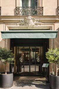 a entrance to a building with a blue awning at Hotel Belleval in Paris