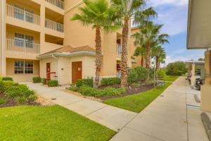 a sidewalk in front of a building with palm trees at Fort Myers Condo on 1st Floor Near Shops and Golf in Fort Myers