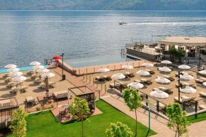 an outdoor patio with umbrellas and a swimming pool at Grand Hotel Victoria concept & spa, by R Collection Hotels in Menaggio