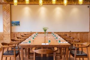 和平乡Longsheng Xichuangyue B&B Hotel的一间有长桌和椅子的大会议室