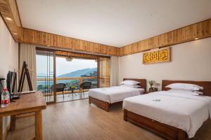 和平乡Longsheng Xichuangyue B&B Hotel的有两张床和一个阳台的酒店房间