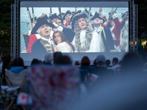 a crowd of people watching a movie on a screen at Harbour Stays at Ocean Square in Saundersfoot