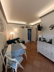 a living room with a table and chairs and a tv at Le Macine Pugnochiuso Holidays in Vieste +46 photos