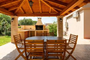 a patio with a table and chairs and a stove at Villa Giovanna - Relax Beach 80m in Solanas