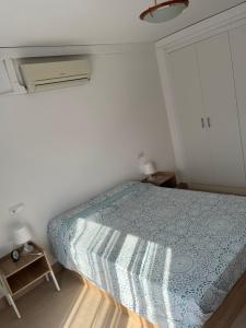 a bedroom with a bed with a blue comforter at Vacaciones en la playa in Sant Carles de la Ràpita