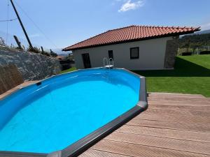 a large blue swimming pool in front of a house at Cantinho Sto Amaro in Arcos de Valdevez