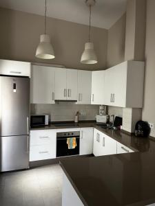 a kitchen with white cabinets and a black counter top at La terraza de la subbética in Luque