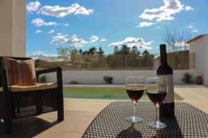 two glasses of wine sitting on a table with a bottle of wine at Monte das Pedras in Abrantes