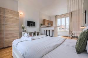 a large white bedroom with a large white bed at Grand Place very well located studio in Lille
