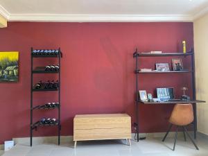 a room with a red wall with racks of shoes at Kayemville in Kasoa