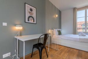 a bedroom with a desk and a bed and a window at Grand Place very well located studio in Lille
