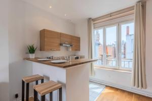 a kitchen with a counter and a large window at Grand Place very well located studio in Lille +12 photos