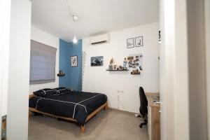 a bedroom with a bed and a desk in it at Casa brisa in Tel Aviv