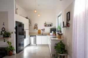 a kitchen with white appliances and plants in it at Casa brisa in Tel Aviv