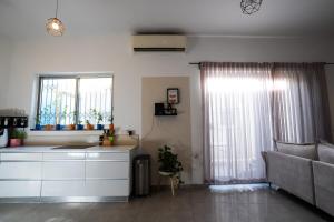 a living room with a couch and a window at Casa brisa in Tel Aviv +84 photos
