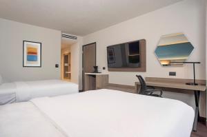 a hotel room with two beds and a desk and a tv at Holiday Inn Express Guadalajara Expo by IHG in Guadalajara +118 photos
