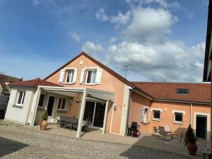 a house with chairs and tables in front of it at paddock pétillant in Auménancourt-le-Grand