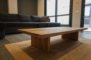 a wooden coffee table in a living room with a couch at Cal Teca Rural in Sant Antolí i Vilanova +34 photos