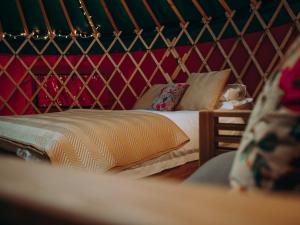 Cama pequeña en habitación con pared roja en Moss Yurt - Uk47888, en Keilour