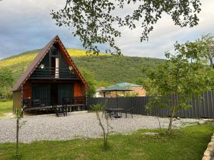 a small house with a hill in the background at Tuta Cottage near Martvili Canyon in Martvili