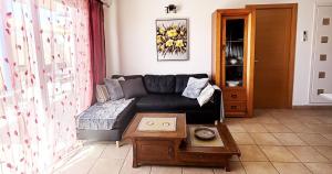 a living room with a black couch and a table at Casa Barmalei Private Pool & Rooftop Terrace Ocean View, Tenerife in Callao Salvaje