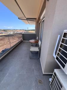 a balcony with a table and chairs on a building at Fred apartment in Nea Fokea