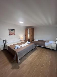 two beds in a room with wooden floors at Fred apartment in Nea Fokea