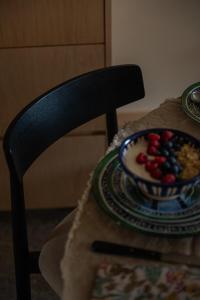 a table with a bowl of fruit on a chair at Coelho 145 in Porto +16 photos