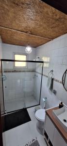 a bathroom with a shower and a toilet and a sink at Demetrio House in Santo Antônio do Pinhal