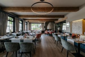a restaurant with tables and chairs and a chandelier at Marie Siska Boutique hotel in Knokke-Heist