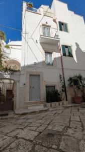 Un edificio blanco con una puerta al costado. en Saliscendi in centro, en Putignano